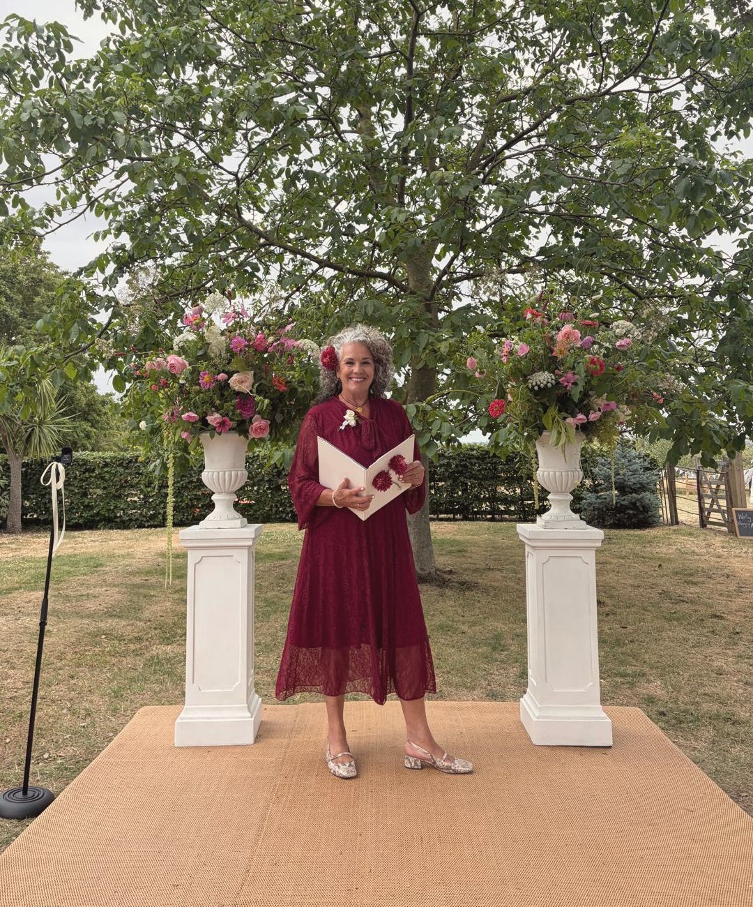 Leah leading a summer garden wedding between two urns of flowers