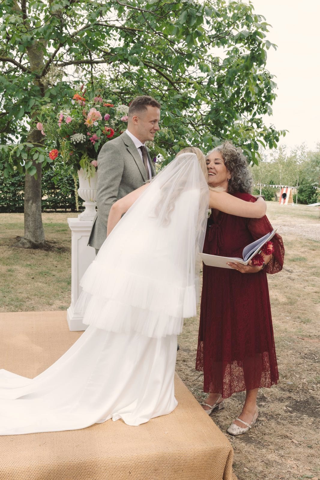 Leah embracing the bride after a garden wedding